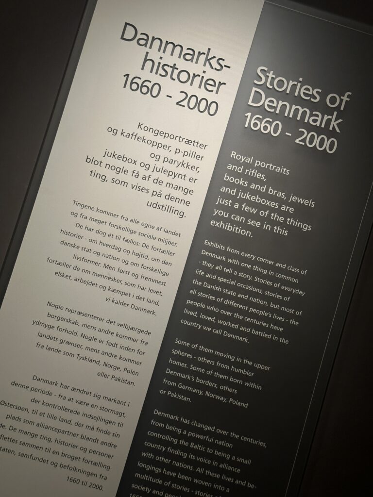 Exhibit panels in Danish and English reading 'Danmarks-historier 1660-2000' and 'Stories of Denmark 1660-2000' with descriptive exhibition text nearby.