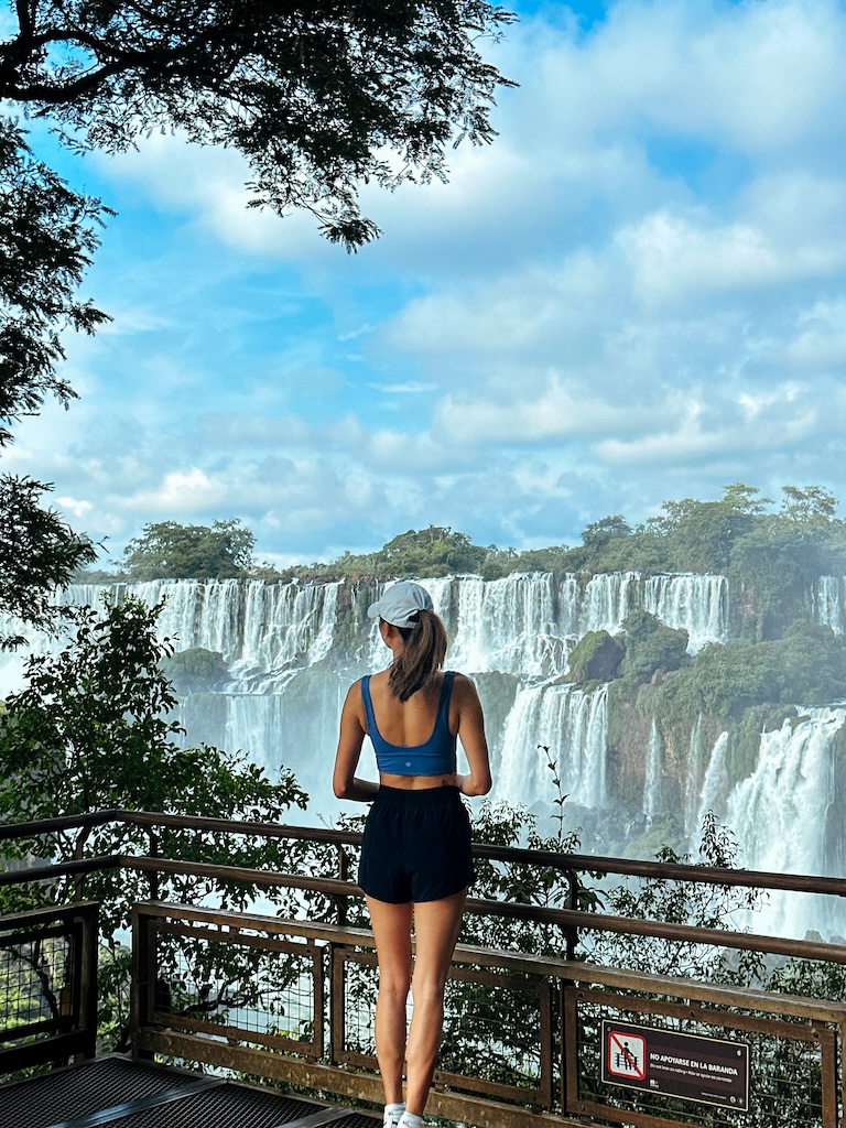 girl standing in front of iguazu falls in argentina and brazil