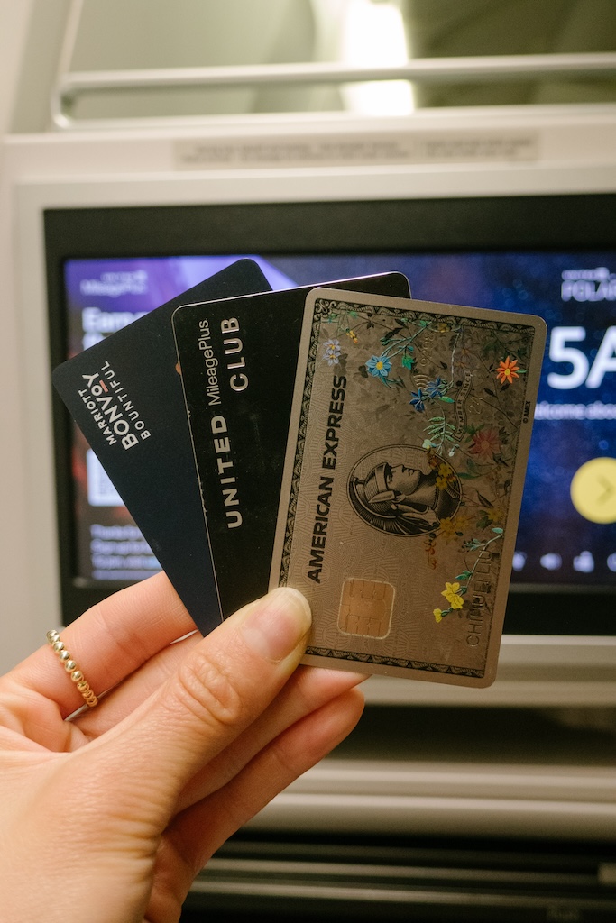 travel credit cards being held up to discuss how to travel for free using credit points and miles